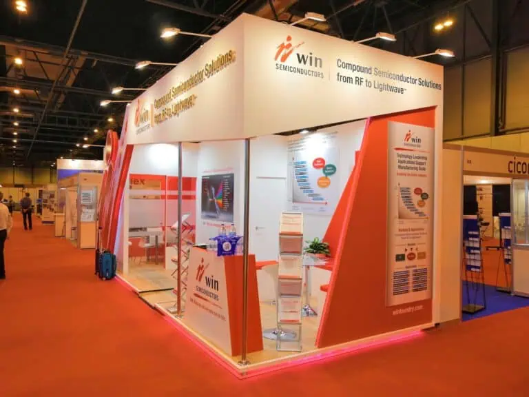 WIN Semiconductors exhibition stand with red and white design at international electronics and microwave trade show