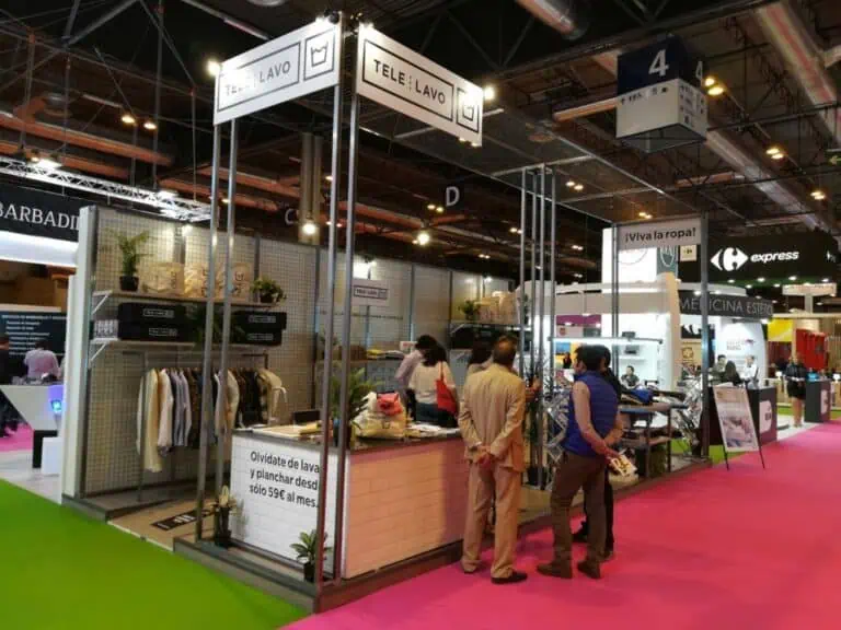Telelavo laundry service startup exhibition stand with hanging signs and clothing display at Madrid trade fair