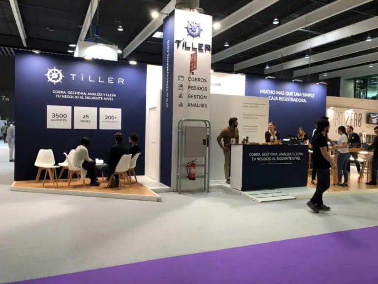 Tiller Systems point of sale software booth with navy blue branding and meeting tables at technology trade fair in Spain