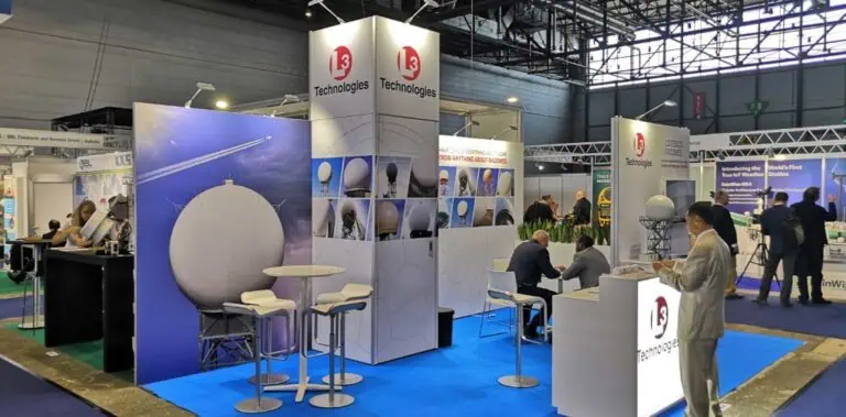 L3 Technologies ESSCO radomes exhibition stand with radome photo towers and blue carpet at European technology expo