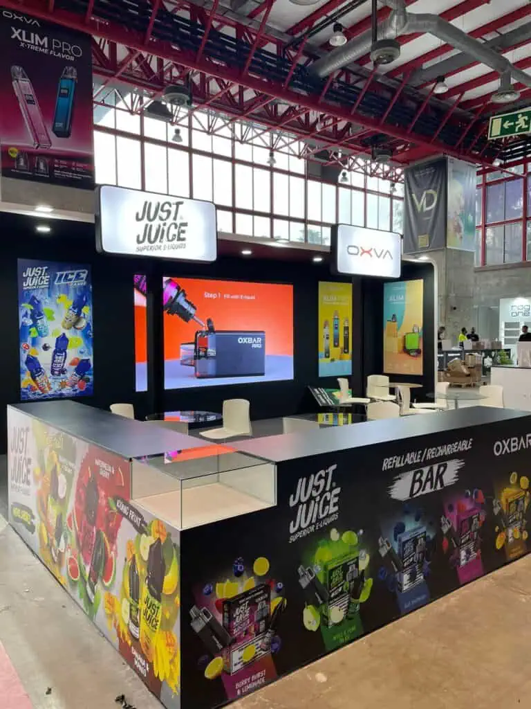 Just Juice and OXVA custom trade show booth with vibrant printed counters and LED screen at consumer brands expo