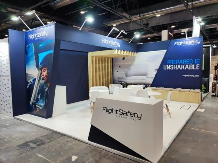 FlightSafety International exhibition booth with pilot graphics and wooden slat feature wall at IFEMA Madrid trade show