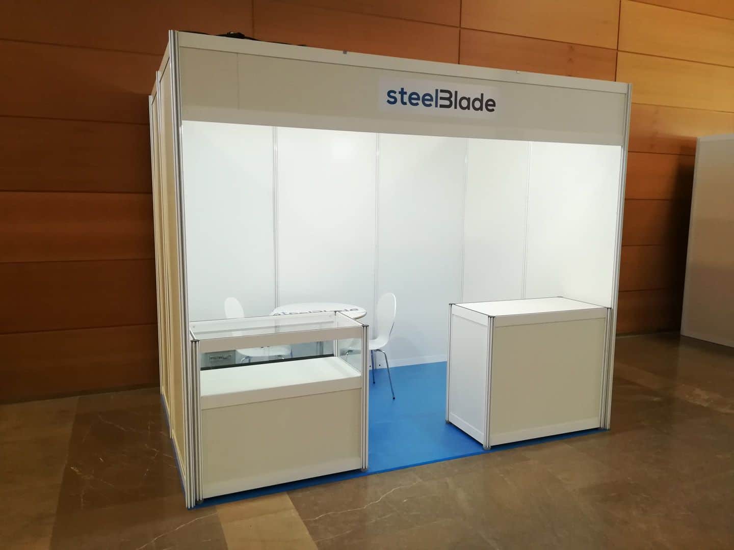 SteelBlade white modular shell scheme booth with counters and fascia branding at Spanish trade fair venue