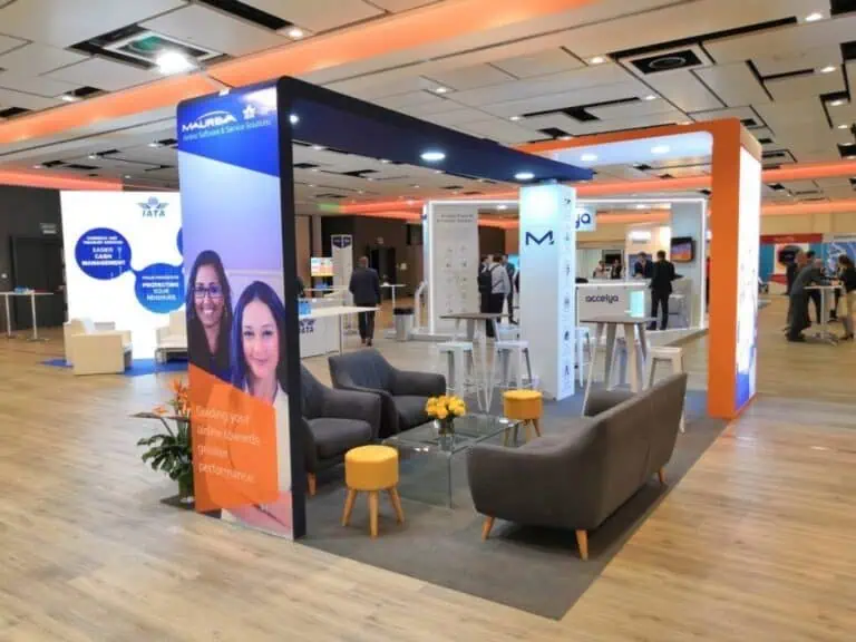 Maureva airline software conference booth with orange and blue branding and lounge seating at IATA airline industry event